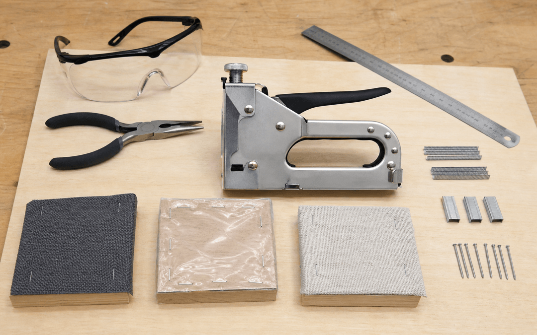 Metall-Handtacker mit Klammern, Nägeln, Materialproben, Schutzbrille, Zange und Lineal im Werkstatttest
