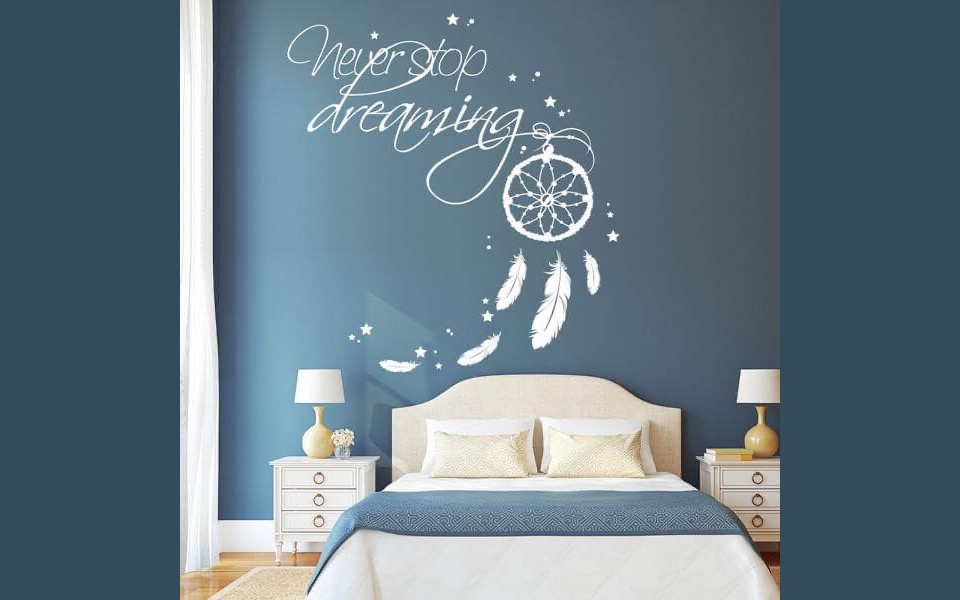 Historisches weißes Traumfänger-Wandtattoo mit dem Schriftzug Never stop dreaming auf dunkelblauer Schlafzimmerwand