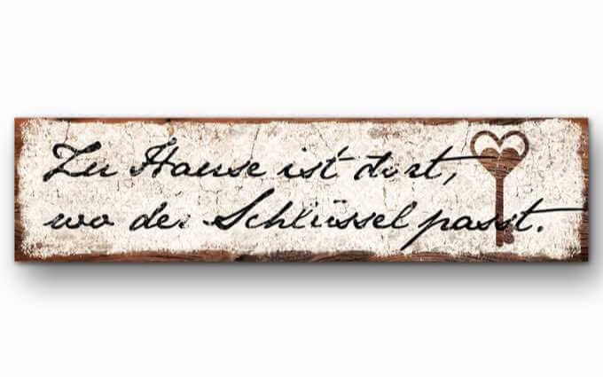 Schmales Holzschild mit dem Schriftzug Zu Hause ist dort, wo der Schlüssel passt