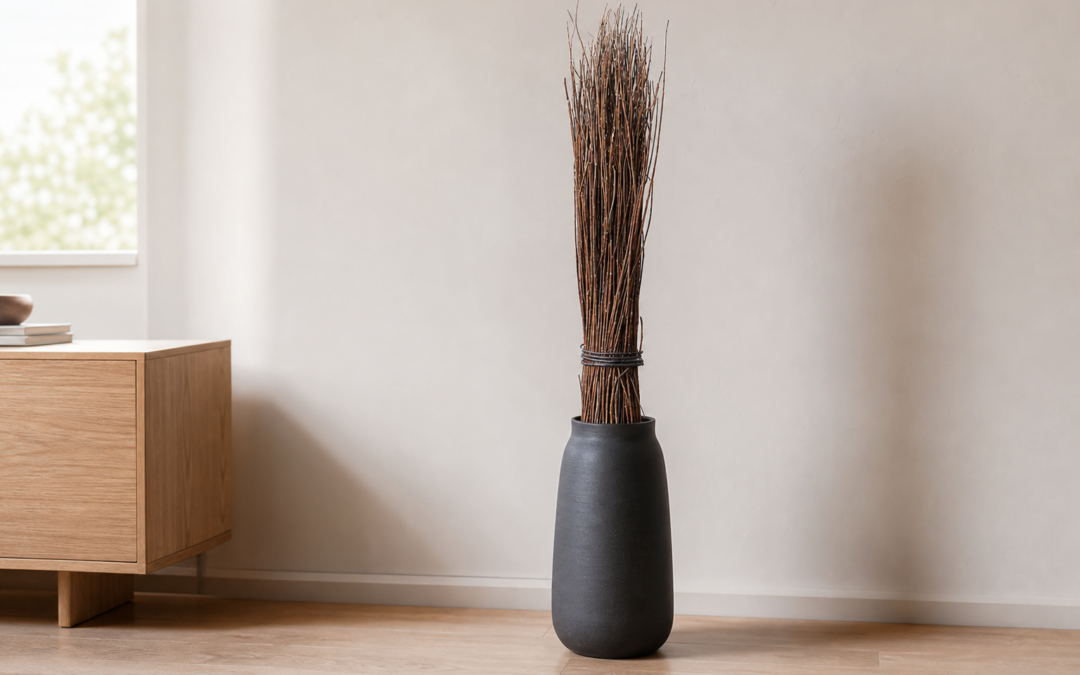 Hohes Bündel aus natürlichen Weidenzweigen in einer standsicheren dunklen Bodenvase