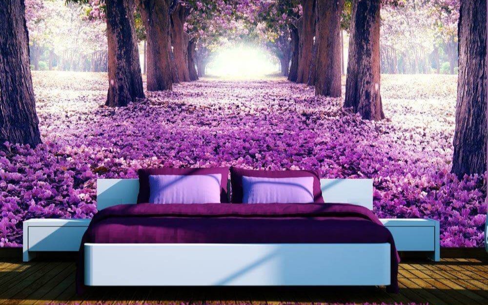 Schlafzimmer mit violetter Vlies-Fototapete aus blühenden Bäumen und langem Waldweg