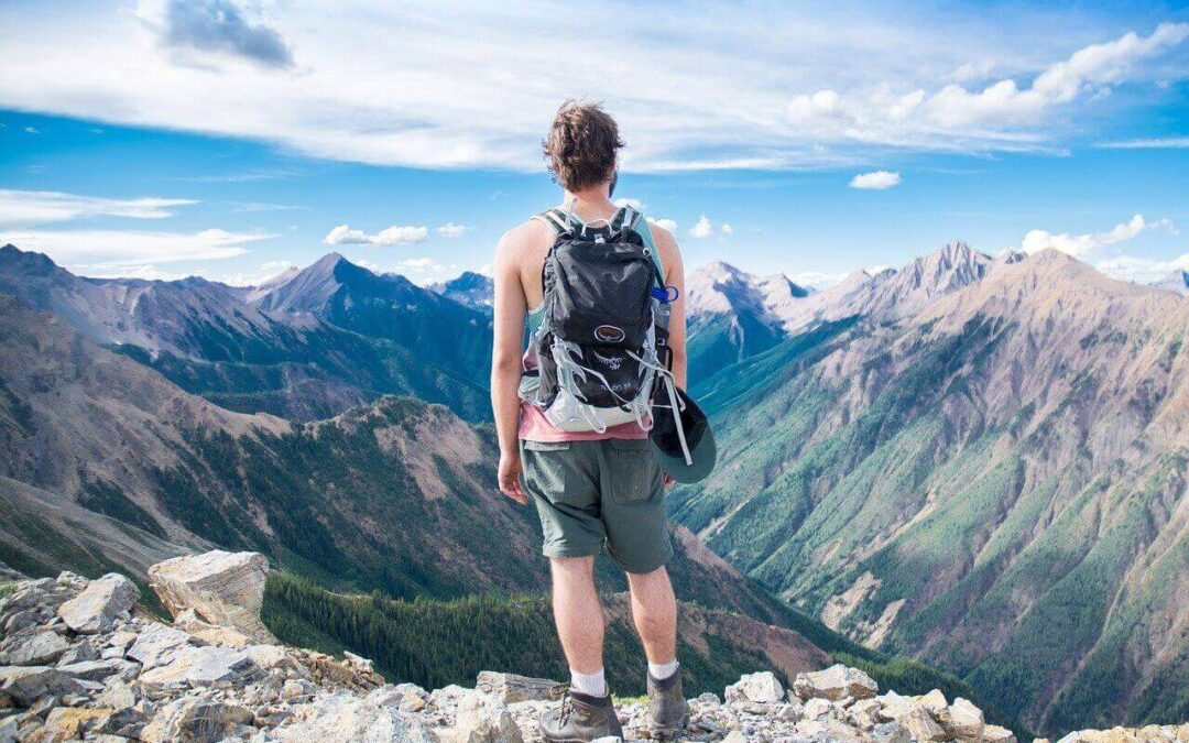 Wanderer mit Tagesrucksack an einem Aussichtspunkt im Gebirge