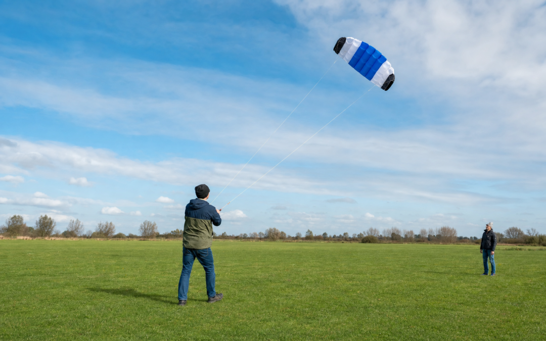 Einsteiger fliegt eine Zweileiner-Lenkmatte auf einer freien Wiese